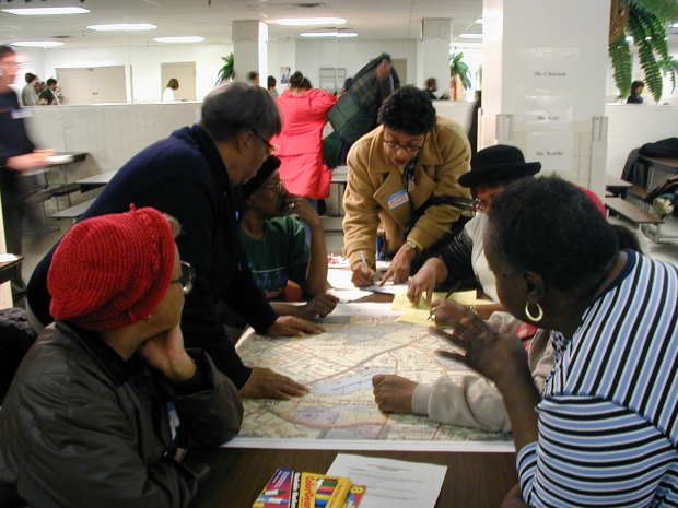 A group of African American women gathered at a table looking at a map.