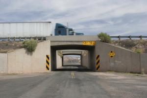 A semi truck crosses a bridge on a rural highway