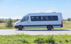 van driving on rural roadway, providing a transportation service that supports regional development