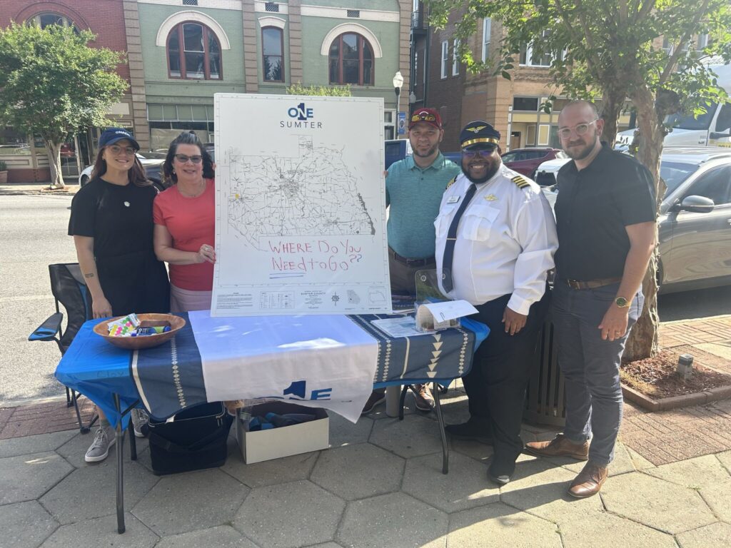 A group of people stand with a printed map to gather community feedback.