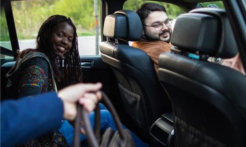A driver and passengers share a ride in a car.